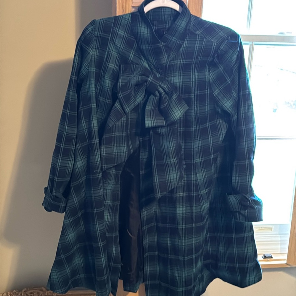 Green and black lined jacket with bow detail.